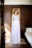 Regal Allure: White Satin Circular Flared Gown with Beaded Illusion Neckline, Net Full Sleeves, Pearl & Sequin Embellishments, and Cowl Draped Front